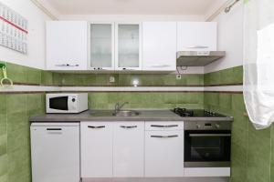 una cucina bianca con un lavello e un forno a microonde di Apartment Vrba a Supetar (San Pietro di Brazza)