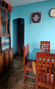 a dining room with a table and chairs and a blue wall at Mountain Paradise Homestay BATASIA LOOP in Darjeeling