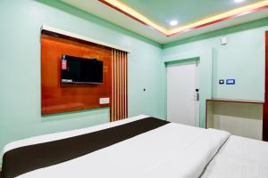 a bedroom with a bed and a tv on the wall at Hotel O GALAXY in Jagatpur