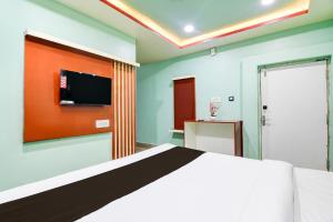 a bedroom with a bed and a tv on the wall at Hotel O GALAXY in Jagatpur +25 photos