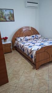 a bedroom with a bed with a wooden headboard at Il Nido del Viaggiatore in Orikum