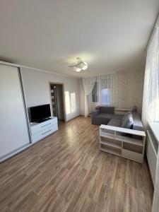 a living room with a couch and a television at Apart Kondratyeva in Sumy