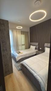 a bedroom with two beds and a chandelier at شقة داخل كمبواند Kayan grand haightsرقم هاتف صفر صفر اتنين صفر واحد واحد صفر اتنين اربعه ثلاثه صفر 222 in 6th Of October