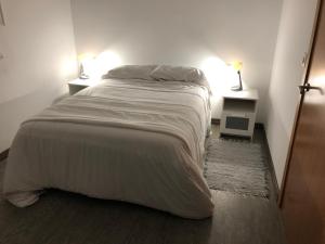 a bedroom with a large bed with two night stands at Cafú Casita entorno natural cerca de Betanzos in Coirós