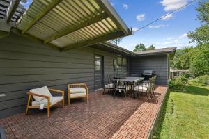 University HeightsにあるIowa City 4BR Backyard Walk to Stadium homeのパティオ(テーブル、椅子、日よけ付)