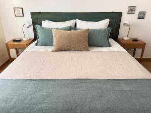 a bedroom with a large bed with blue pillows at WHome Seaside Getaway Beachfront Apartment in Estoril