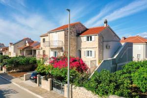 una fila di case in una strada con fiori di Apartment Vrba a Supetar (San Pietro di Brazza)