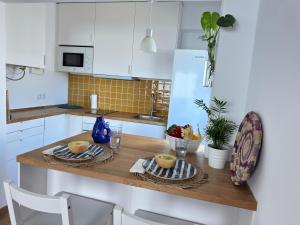 a kitchen with a table with two plates of fruit on it at WHome Seaside Getaway Beachfront Apartment in Estoril
