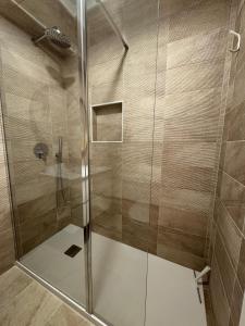 a shower with a glass door in a bathroom at WHome Seaside Getaway Beachfront Apartment in Estoril +9 photos