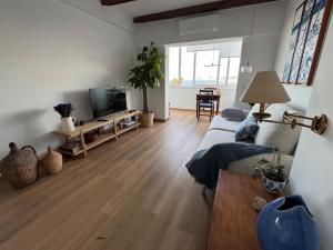 a living room with a couch and a flat screen tv at WHome Seaside Getaway Beachfront Apartment in Estoril