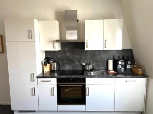 a white kitchen with white cabinets and a sink at Charmante Altbauwohnung im Herzen von Rastatt kostenloser Parkplatz in Rastatt