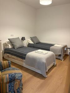 马尔科-德卡纳维泽斯Casa Moderna na Aldeia的有两张床和一把椅子的卧室 更多49张照片