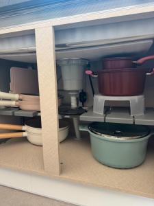 a cabinet filled with pots and pans in a kitchen at Gyeongju Bulguksa Family House Stay Mute in Gyeongju +42 photos