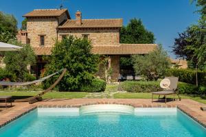 a swimming pool in front of a house at Scappo in Umbria, casale della quiete in Montecchio +29 photos