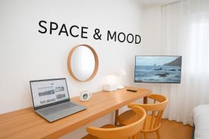 a room with a desk with a laptop and a mirror at SPACE & MooD in Busan
