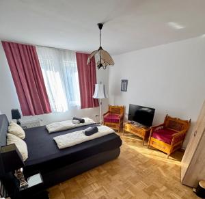 a bedroom with two beds and a television in it at Altstadt Apartmenthaus in Kassel