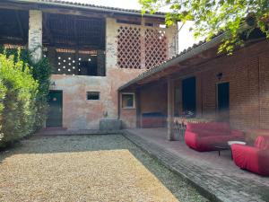 a patio with red furniture and a brick building at Casa Biloba in Valdengo