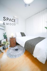 a bedroom with two beds and a rug at SPACE & MooD in Busan