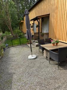 a patio with an umbrella and tables and chairs at Lägenhet i Kosta in Kosta