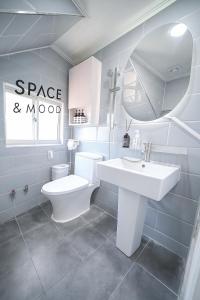 a bathroom with a toilet and a sink and a mirror at SPACE & MooD in Busan