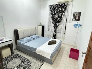 a bedroom with a bed and a window at D'Widuri Homestay Bandar Melaka in Melaka