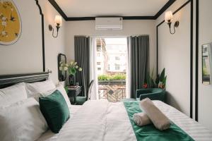 a bedroom with a large white bed and a window at Willow Hanoi Old Quarter in Hanoi