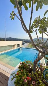 カマラビーチにあるBeautiful Sea 1BR apart A6のヤシの木と建物のあるスイミングプール