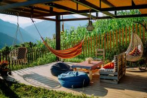 a patio with a hammock and a table and chairs at Lemanor lodge - Mountain Cottage in Adjara, Georgia in Kʼveda Chʼkhutunetʼi