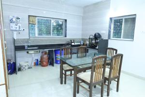 a kitchen with a table and chairs in a room at Hide away stay in Pune