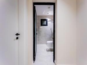 een badkamer met toilet en glazen deur bij Comfy apartment in AlKhobar in Al Khobar