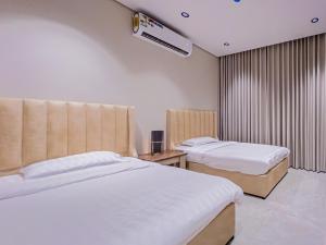 een hotelkamer met 2 bedden en airconditioning bij Comfy apartment in AlKhobar in Al Khobar