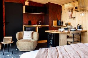 Una habitación con una cama y una mesa y una cocina. en Lodges d'Exception avec jacuzzi privé I Montluçon I Auvergne, en Prémilhat