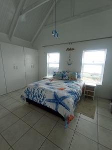 a bedroom with a bed with an octopusidered bedspread at The Tides Holiday Home in St Helena Bay