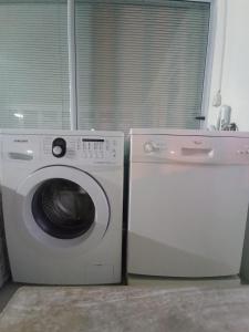 a washing machine and a washer in a room at The Tides Holiday Home in St. Helena Bay