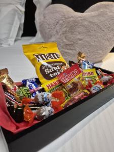 a tray of candy on top of a bed at Love Room, balnéo, lit king-size, douche XXL etc in Rochefort