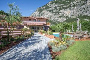 a house with a swimming pool next to a mountain at Agriturismo Vin e Amor in Dro