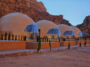 a row of domes with a mountain in the background at Wadi Rum Hakuna Matata Camp and Jeep Tour in Disah