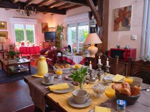 una sala de estar con una mesa con comida. en Les Roses, en Santec