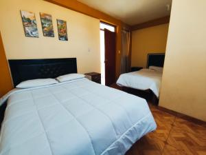 a hotel room with two beds and a window at Posada de Zarita in Chivay