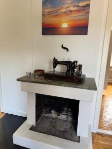 a sewing machine sitting on top of a fireplace at Naturnära boende i Kosta in Kosta