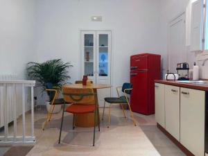 a kitchen with a table and a red refrigerator at Dimora a Palazzo in Monopoli
