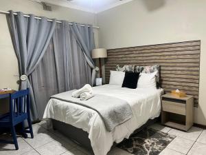 ヨハネスブルグにあるMap's View Guesthouseの木製のヘッドボードが付いた大きなベッドのある寝室 +138枚の写真