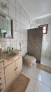 Un baño con lavabo, inodoro y espejo. en Thom's House, en Santa Teresa 10 fotos más