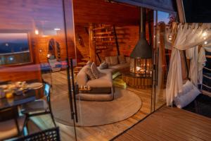 ein Wohnzimmer mit zwei Sofas und einem Tisch in der Unterkunft Chalé Boutique Spa- Sauna seca, Jacuzzi , Rede suspensa in Campos do Jordão + 78 Fotos