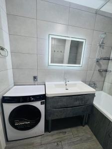 ein Badezimmer mit Waschbecken und Waschmaschine in der Unterkunft Amarant Apart Hotel VB in Sumy