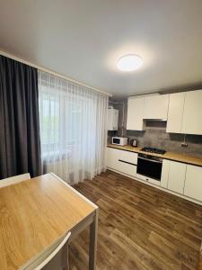 eine Küche mit weißen Schränken und einem Holzboden in der Unterkunft Amarant Apart Hotel VB in Sumy