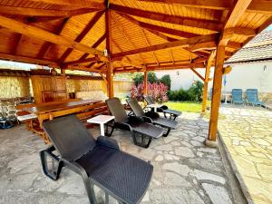 a group of chairs sitting under a wooden pavilion at Family Hotel Carpe Diem in Banya