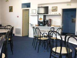 a dining room with black chairs and a table at Hotel Neptune in Montbard