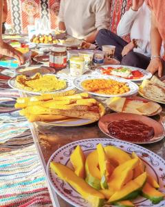 a long table with plates of food on it at White desert camp in Bawiti