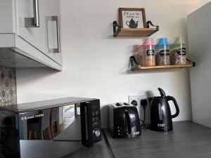 a kitchen with a coffee maker and a microwave at Gatwick Studio in Horley +4 photos